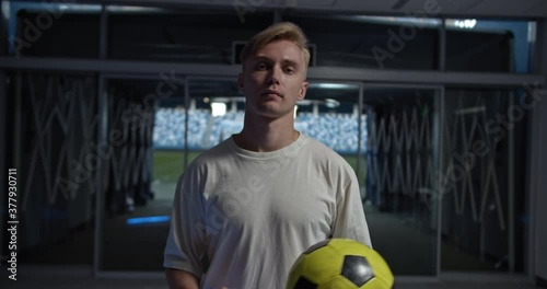 Portrait of young Football coach. Soccer football training session, Football tactic education. Man with ball in stadium near field, professional football team staff