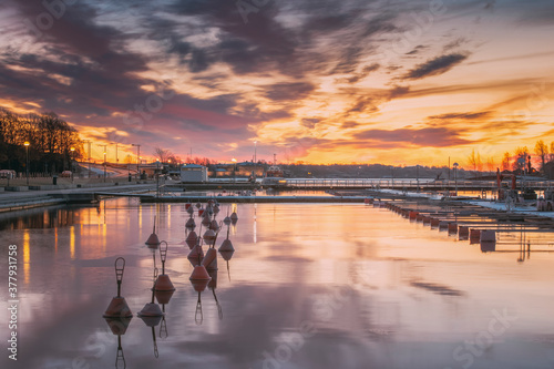 Helsinki, Finland. Landscape With City Pier, Jetty At Winter Sunrise Or Sunset Time. Tranquil Sea Water Surface At Early Morning photo