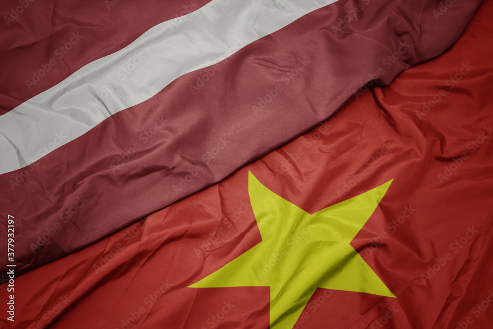 waving colorful flag of vietnam and national flag of latvia. waving colorful flag of vietnam and national flag of latvia.