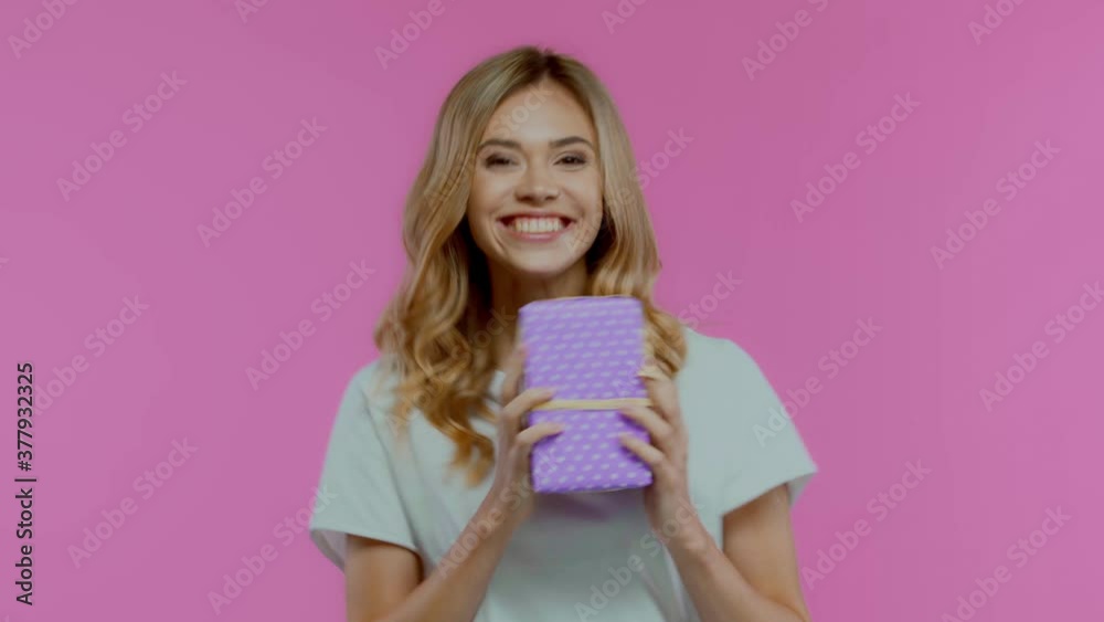 Man giving gift box to blonde woman isolated on purple Man giving gift box to blonde woman isolated on purple