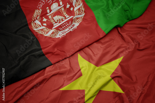 waving colorful flag of vietnam and national flag of afghanistan.