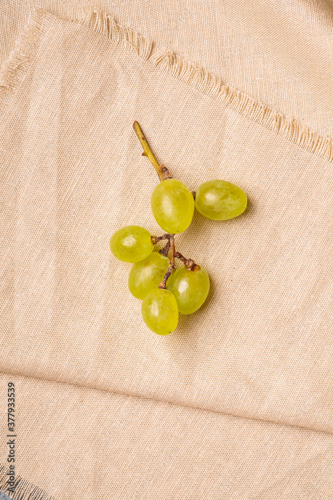 Fresh ripe white grape berries on linen tablecloth, top view macro Fresh ripe white grape berries on linen tablecloth, top view macro