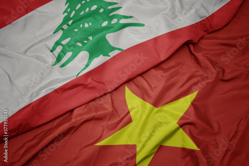 waving colorful flag of vietnam and national flag of lebanon. photo