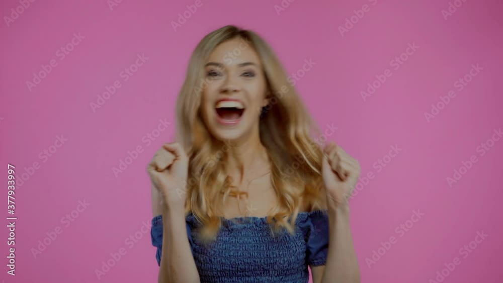 Excited blonde woman dancing and showing yes gesture isolated on purple Excited blonde woman dancing and showing yes gesture isolated on purple