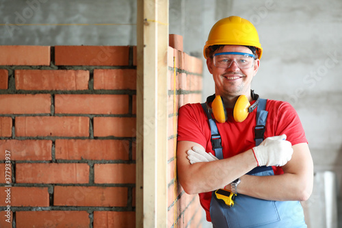 Foto Mason or foreman standing by wall construction