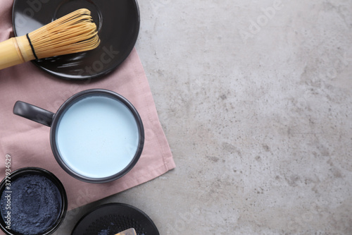 Flat lay composition with blue matcha latte on grey table. Space for text