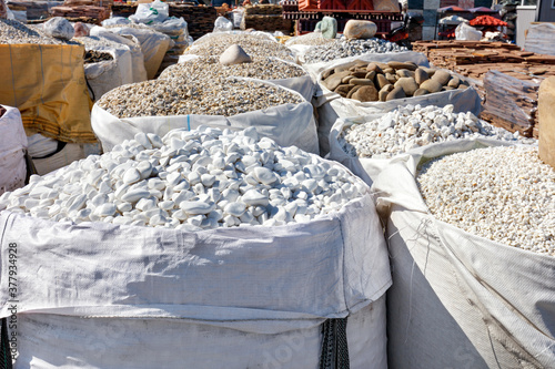 Obraz na płótnie Large bags of stones of different colors and fractions on sale for interior and exterior building finishing. w salonie