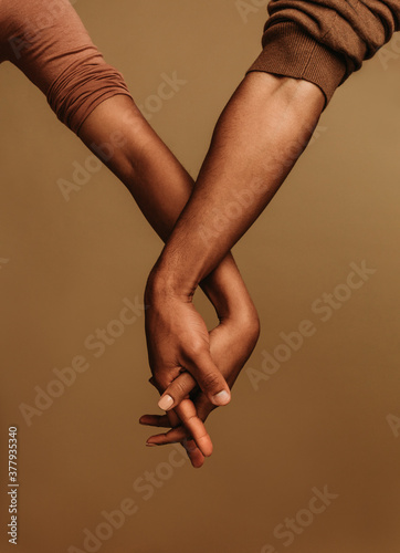 Close up of two hands with fingers interlocked