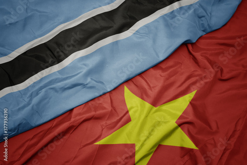 waving colorful flag of vietnam and national flag of botswana.