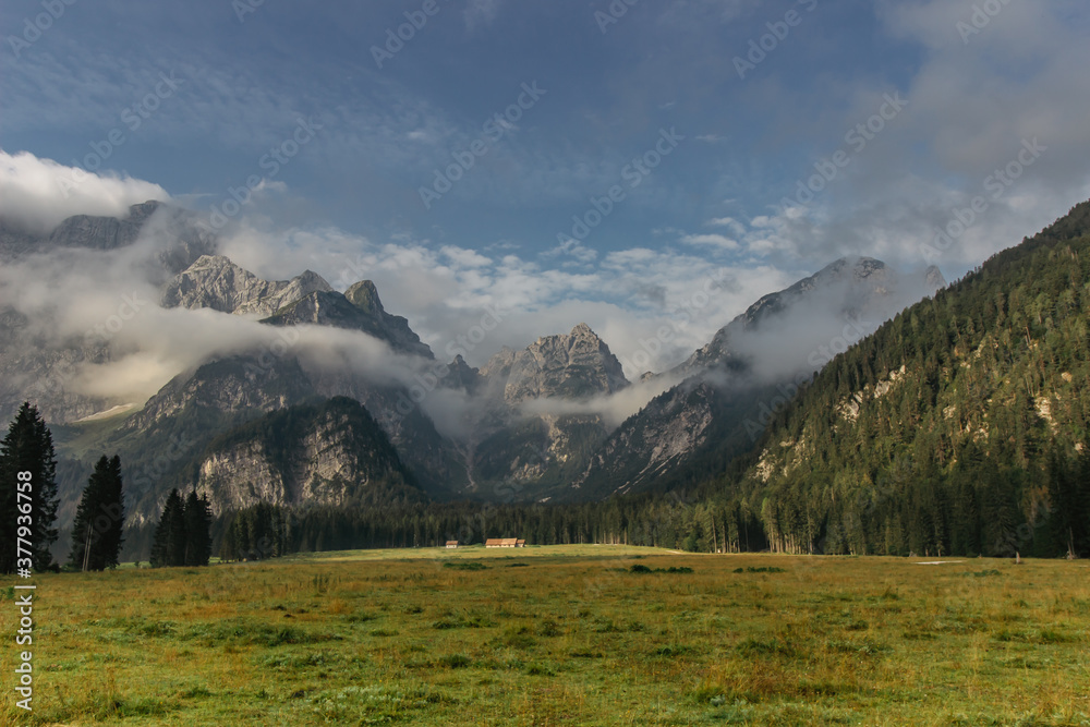 Beautiful view of morning foggy mountain landscape. Remote house surrounded by wild nature,meadows,pasture,Alps.Rural lifestyle in Dolomites,Italy.Calm tranquil atmosphere.Adventure holiday background