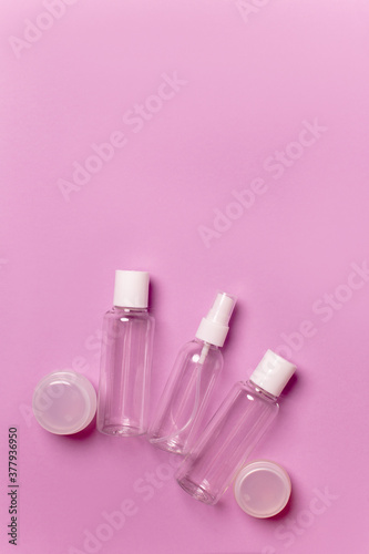 Cosmetic bottles and jars on a pink background