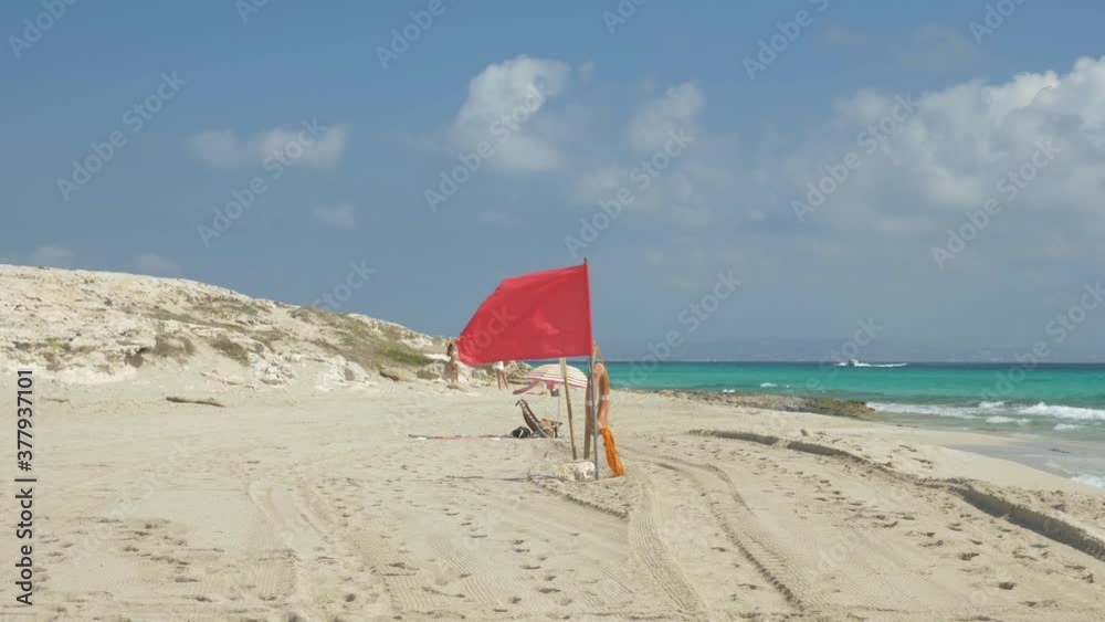 4k Slow-motion red flag on the beach with amazing blue water. 4k Slow-motion red flag on the beach with amazing blue water.