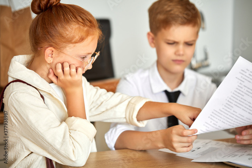 beautiful caucasian couple children work on laptop together, solve family problems, pay bills online, have talk. at home, they behave themselves as adults