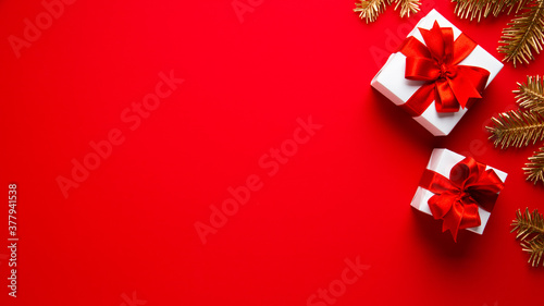 Merry Christmas and Happy Holidays greeting card, frame, banner. New Year. Noel. Christmas ornaments and gift on red background top view. Winter xmas holiday theme. Flat lay	
