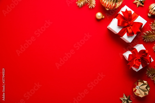 Merry Christmas and Happy Holidays greeting card, frame, banner. New Year. Noel. Christmas ornaments and gift on red background top view. Winter xmas holiday theme. Flat lay	
