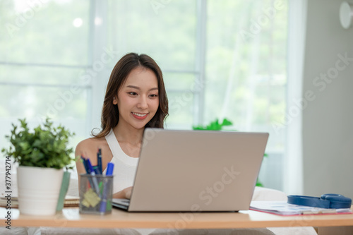 Beautiful Attractive Asian indian woman working with computer laptop and thinking to get ideas and requirement in Business startup at home feeling so happiness,Business Startup Concept © 220 Selfmade studio