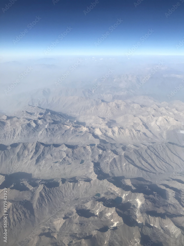 A view from the sky on the Earth. Mountains, sky, nature and landscape from a plane window.