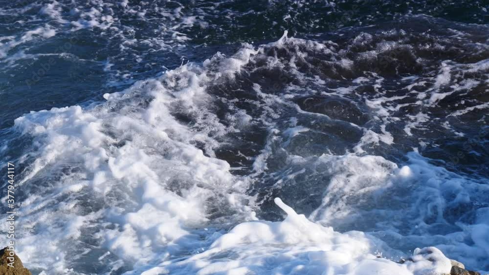 Big waves crashing on the rocks cliff.  Slow motion. View from above