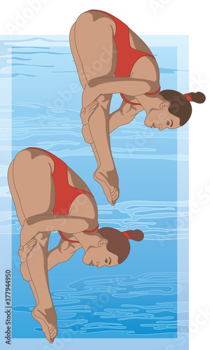 divers, female in synchronized pike diving position with swimming pool in the background