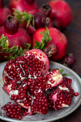 Fresh juicy pomegranate - whole and cut, with leaves on  table.