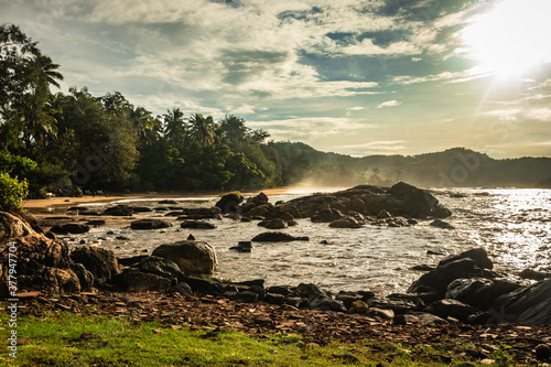 rocky sea beach with crashing waves at morning from flat angle photo