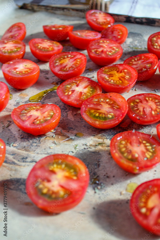 Cherry Tomatoes sliced over a baking tray. Cherry Tomatoes sliced over a baking tray.