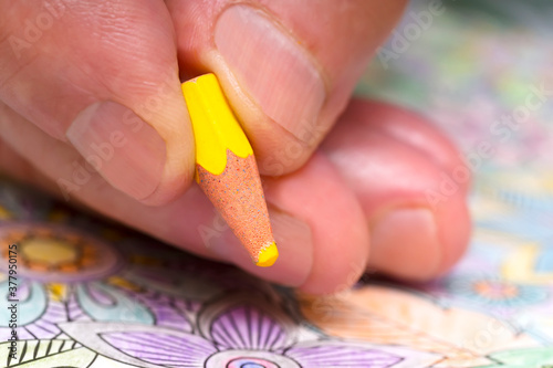 Obraz na plátně senior man painting with very small coloring pencils due to their use , concept