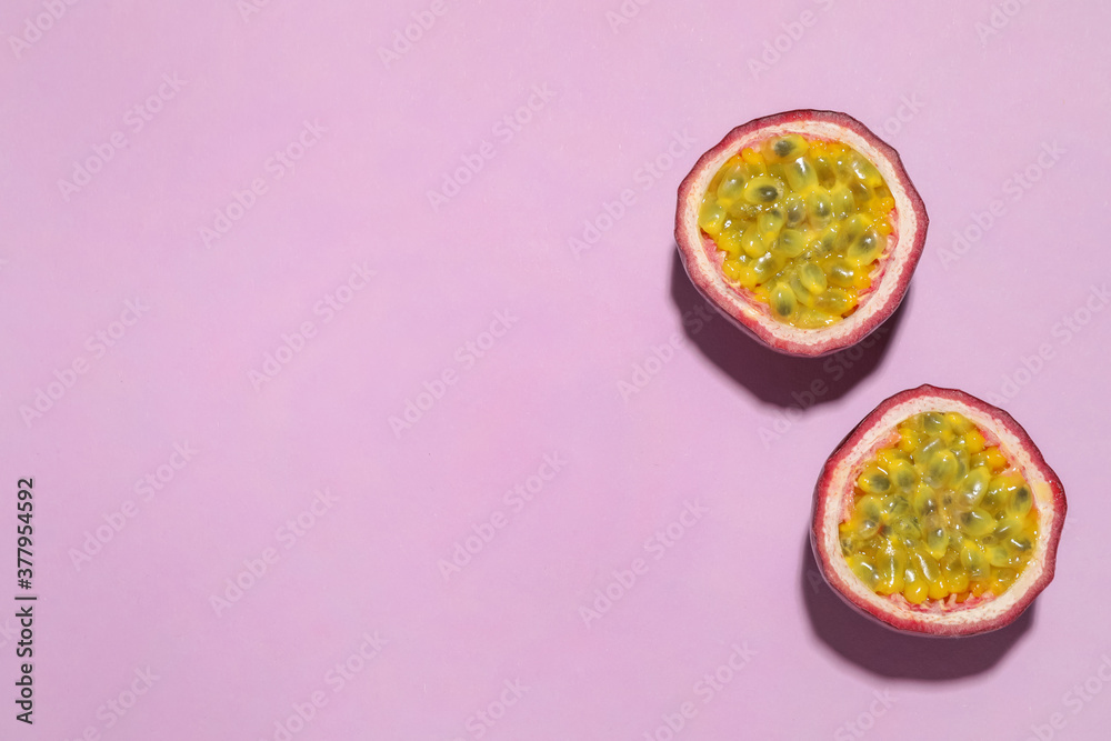 Halves of passion fruit (maracuya) on pink background, flat lay. Space for text Halves of passion fruit (maracuya) on pink background, flat lay. Space for text