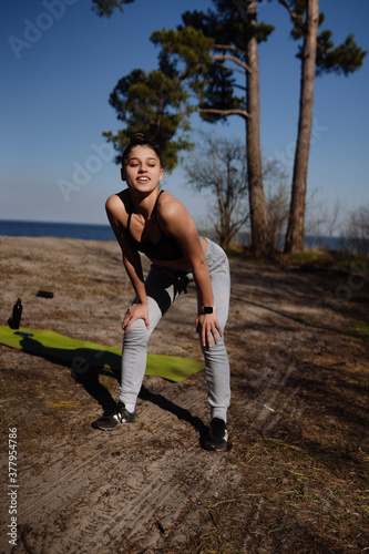 Fitness young woman walks in the park and posing for the camera © teksomolika