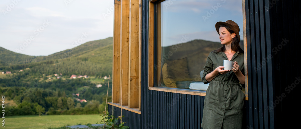 Young woman outdoors, weekend away in container house in countryside. Young woman outdoors, weekend away in container house in countryside.