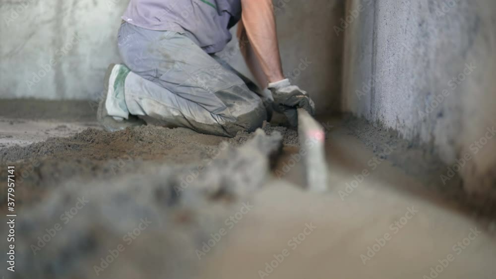 Tool for smooth concrete surface. Worker with tool makes a smooth concrete surface during construction
