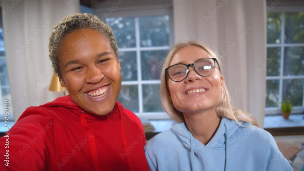 Two beautiful diverse happy girlfriends taking selfies or recording video for blog on social media Two beautiful diverse happy girlfriends taking selfies or recording video for blog on social media