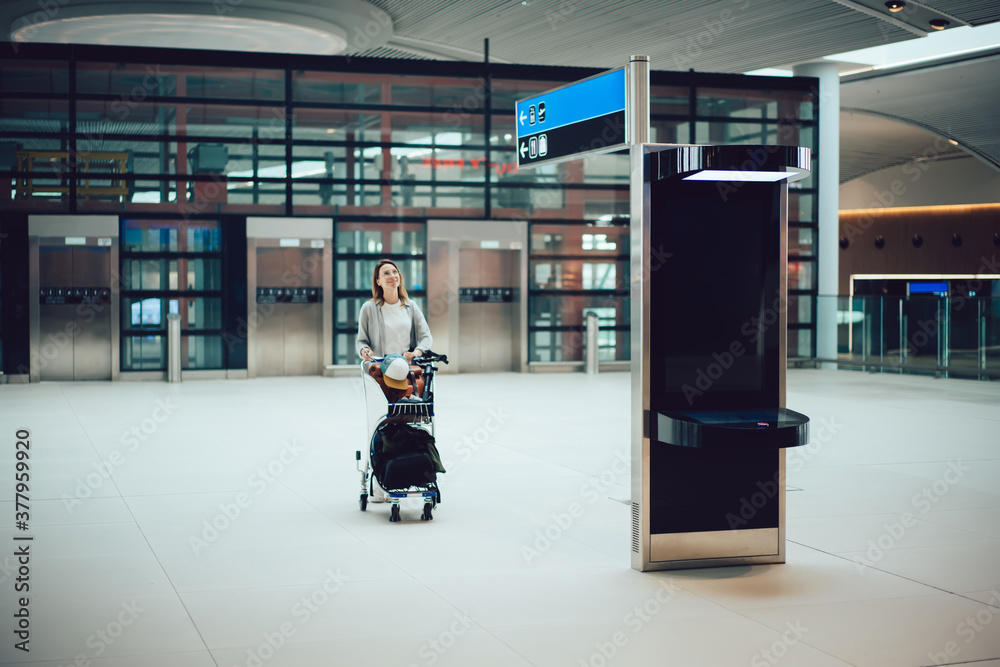 Young woman walking towards information machine in airport Young woman walking towards information machine in airport