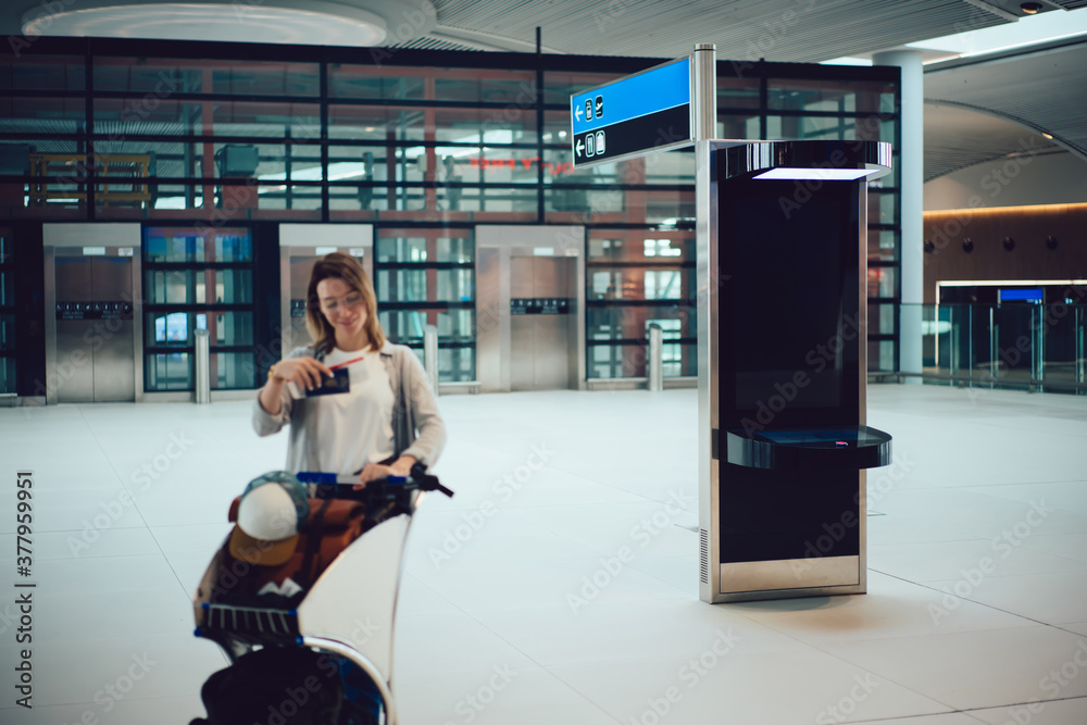 Obraz premium Young woman in eyeglasses with baggage in airport terminal