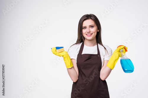 Young woman holding sponge and cleaning product on white background