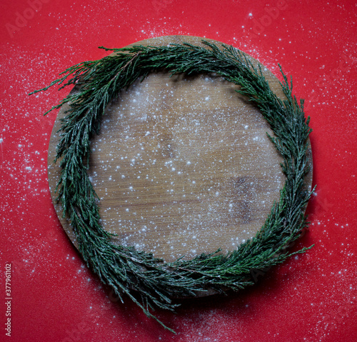 A wreath of fir branches on a wooden Board. Red background. Christmas. High quality photo photo