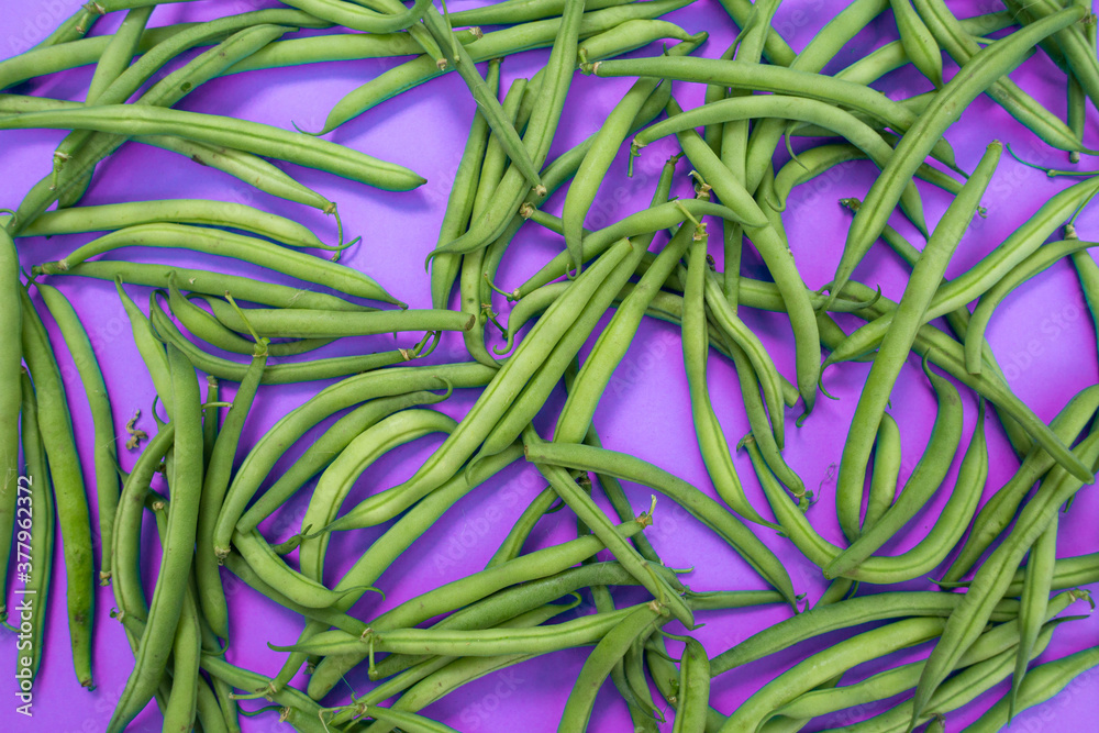 Raw green beans on a colored background