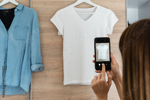 Woman taking picture of used clothes. Selling used clothes concept photo