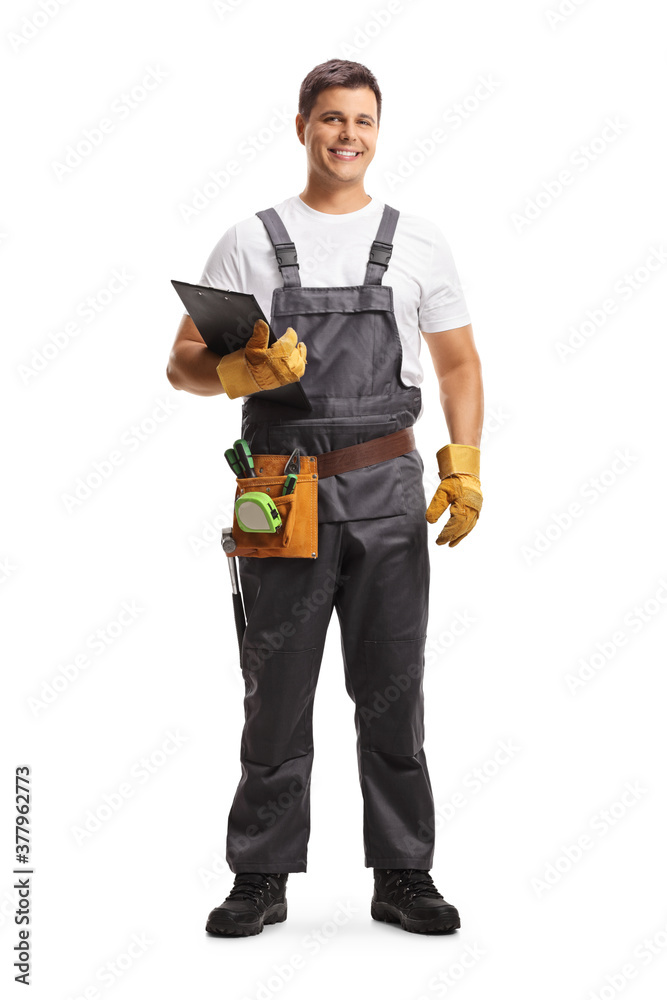 Full length portrait of a male worker with a tool belt holding a clipboard