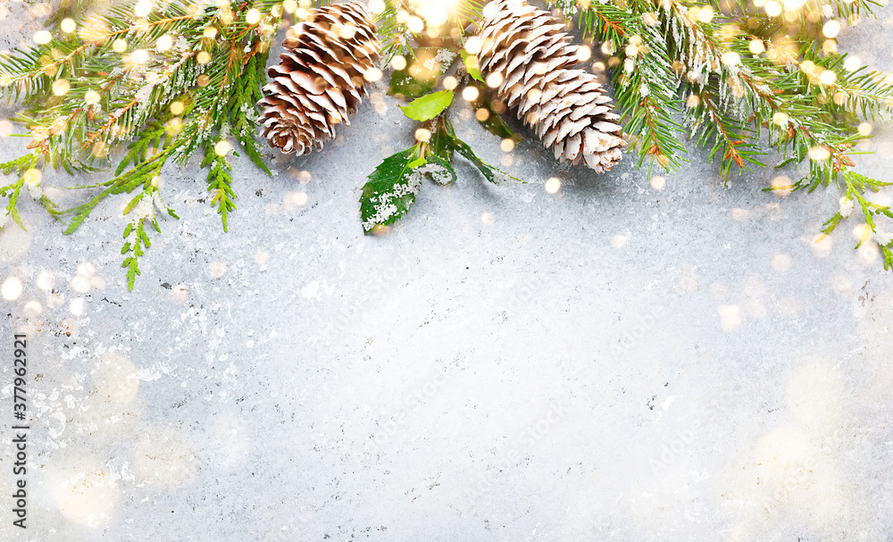 Naklejka Boże Narodzenie lub zima tło z obramowaniem zielonych i matowych gałęzi wiecznie zielonych i szyszek sosnowych na szarym pokładzie vintage. Płaskie ułożenie