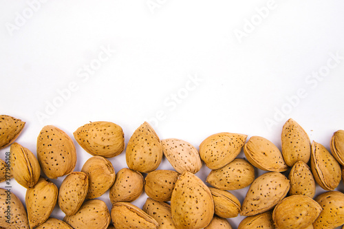 Inshell almonds on a white background. Almonds are arranged in a pile.