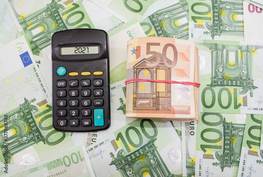 folded euro banknotes and calculator on the money background. Euro banknotes tied with elastic band. Financial concept. folded euro banknotes and calculator on the money background. Euro banknotes tied with elastic band. Financial concept.