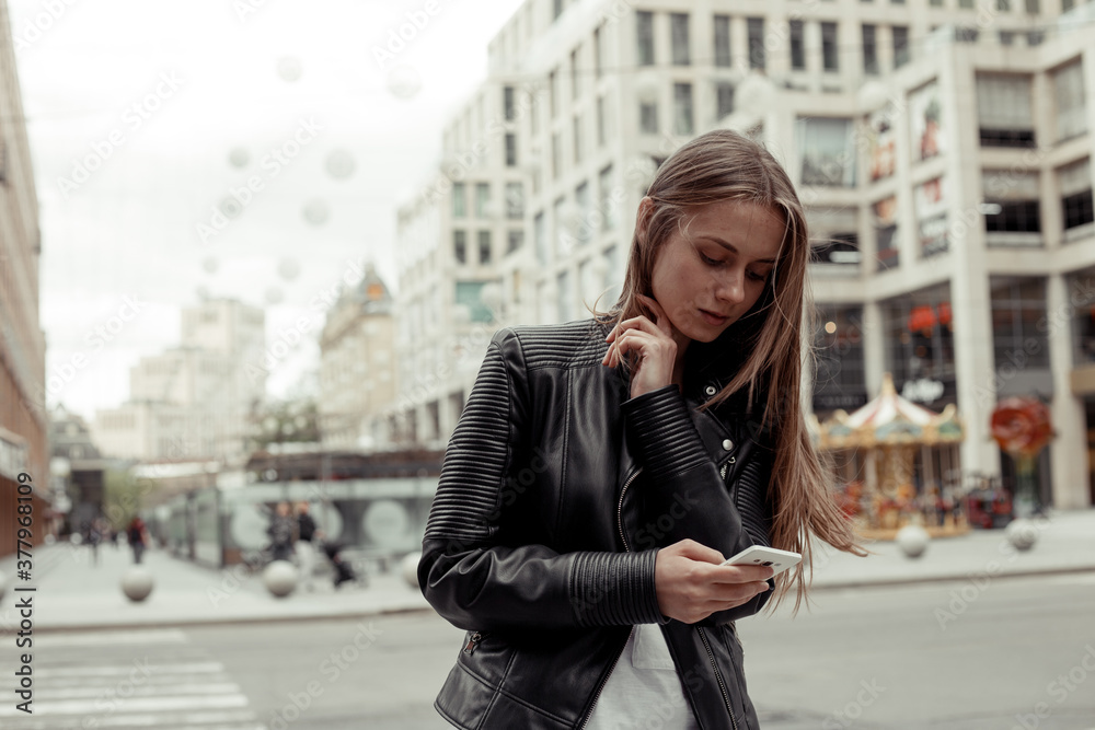 Woman wearing black leather jacket and white shirt write a phone message Woman wearing black leather jacket and white shirt write a phone message