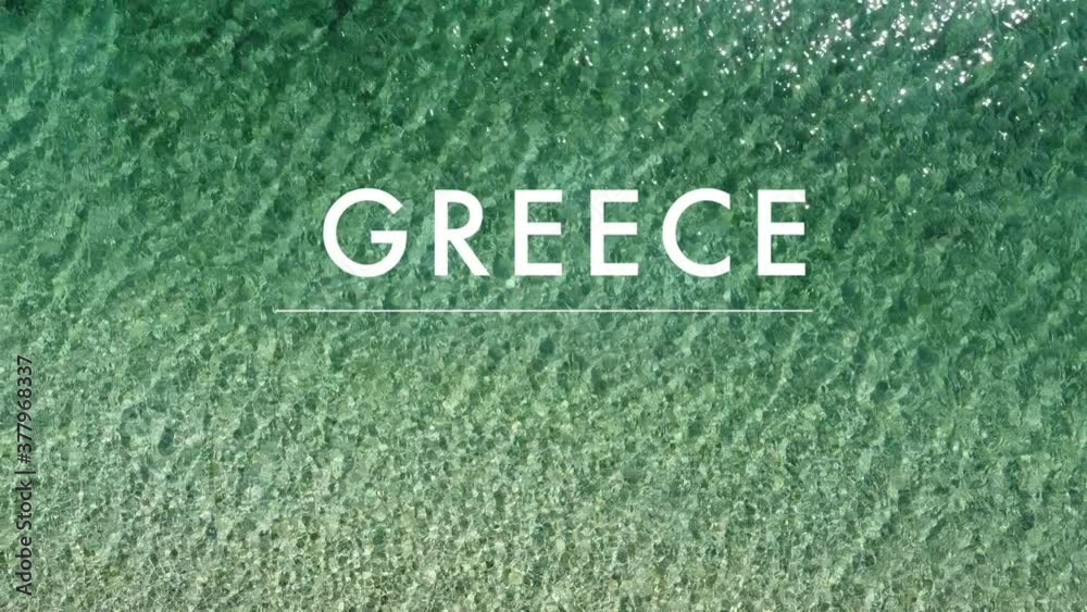 close up of a turquoise greek sea shimmering in the sunlight with the text Greece close up of a turquoise greek sea shimmering in the sunlight with the text Greece