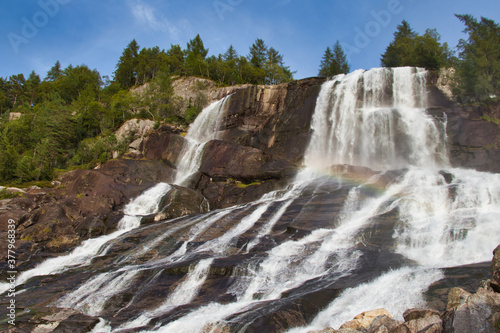 Beautiful Furebergsfossen waterfall in Norway, waterfall on rocky slope near road along the Hardangerfjord fiord