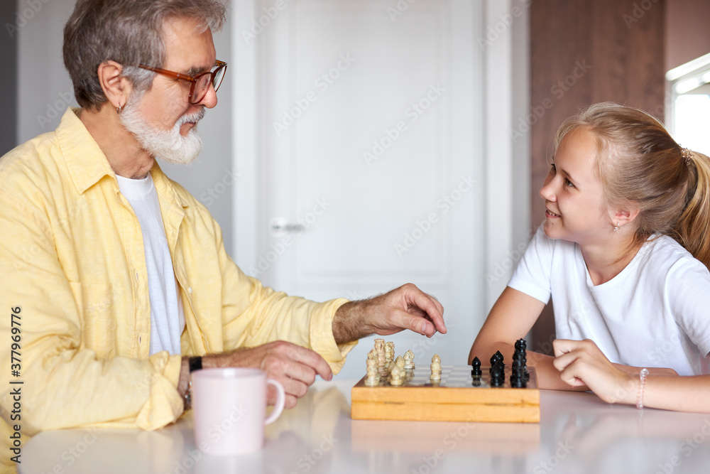 granddad transferring knowledge to young generation of family, mindful grandfather teaching granddaughter how to play chess granddad transferring knowledge to young generation of family, mindful grandfather teaching granddaughter how to play chess