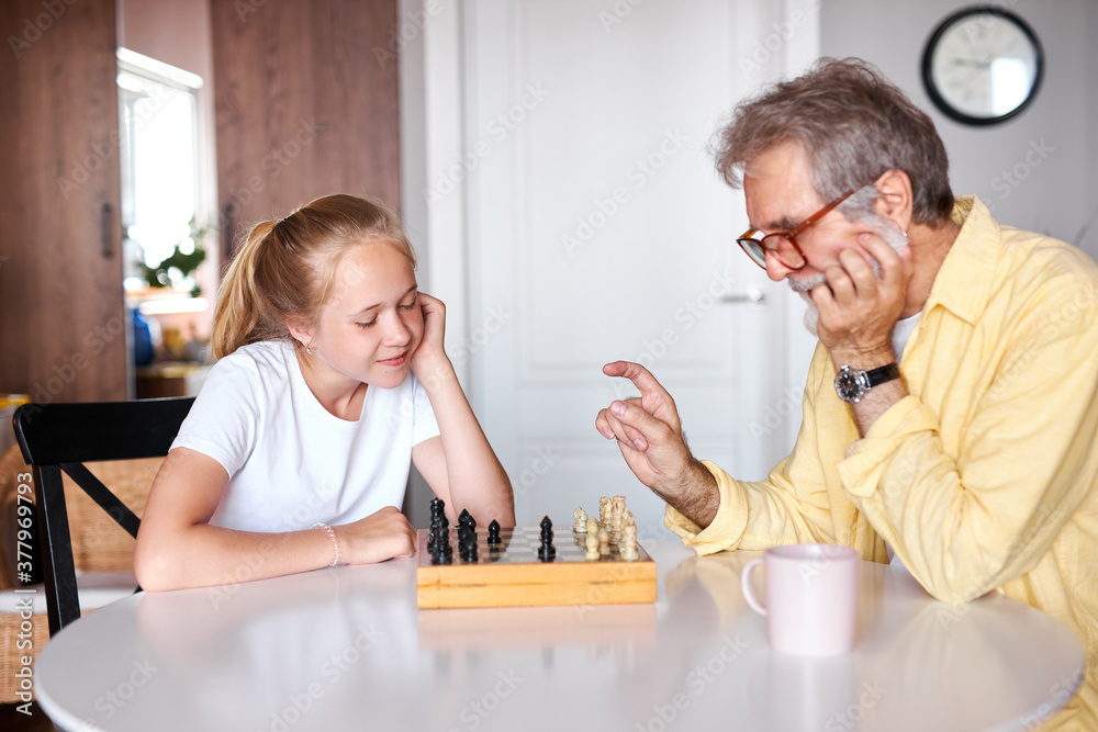granddad transferring knowledge to young generation of family, mindful grandfather teaching granddaughter how to play chess granddad transferring knowledge to young generation of family, mindful grandfather teaching granddaughter how to play chess