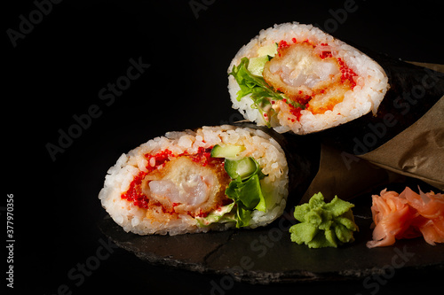  sushi burrito , sushiritto, with  shrimp rice, spice sauce, cucummber, lettuce, nori, on a black background