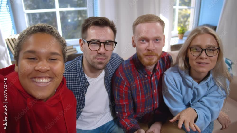 Trendy young multiracial friends taking selfie or having video chat or filming blog sitting at home Trendy young multiracial friends taking selfie or having video chat or filming blog sitting at home