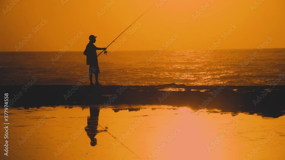 A Moroccan man fishing on fishing rod at sunset. Rabat, Morocco. A Moroccan man fishing on fishing rod at sunset. Rabat, Morocco.